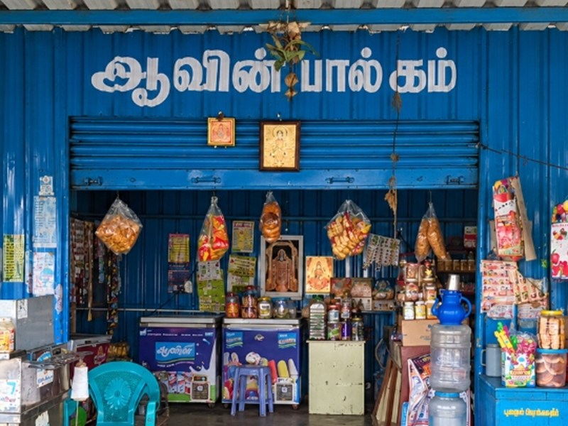 Close-up photograph of Aavin Paalagam Naidumangalam blue shutter signage.